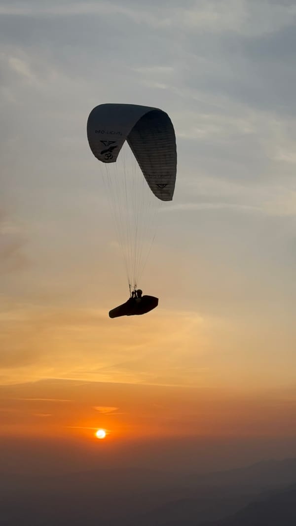 Paraglider silhouette at golden hour over Bir Billing
